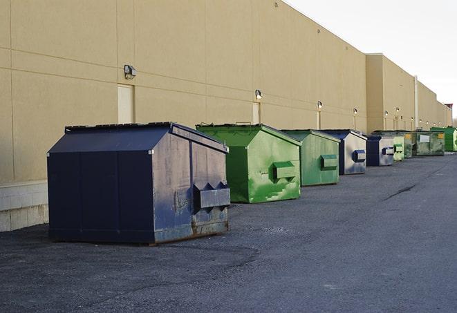 a row of yellow and blue dumpsters at a construction site in Bartonville